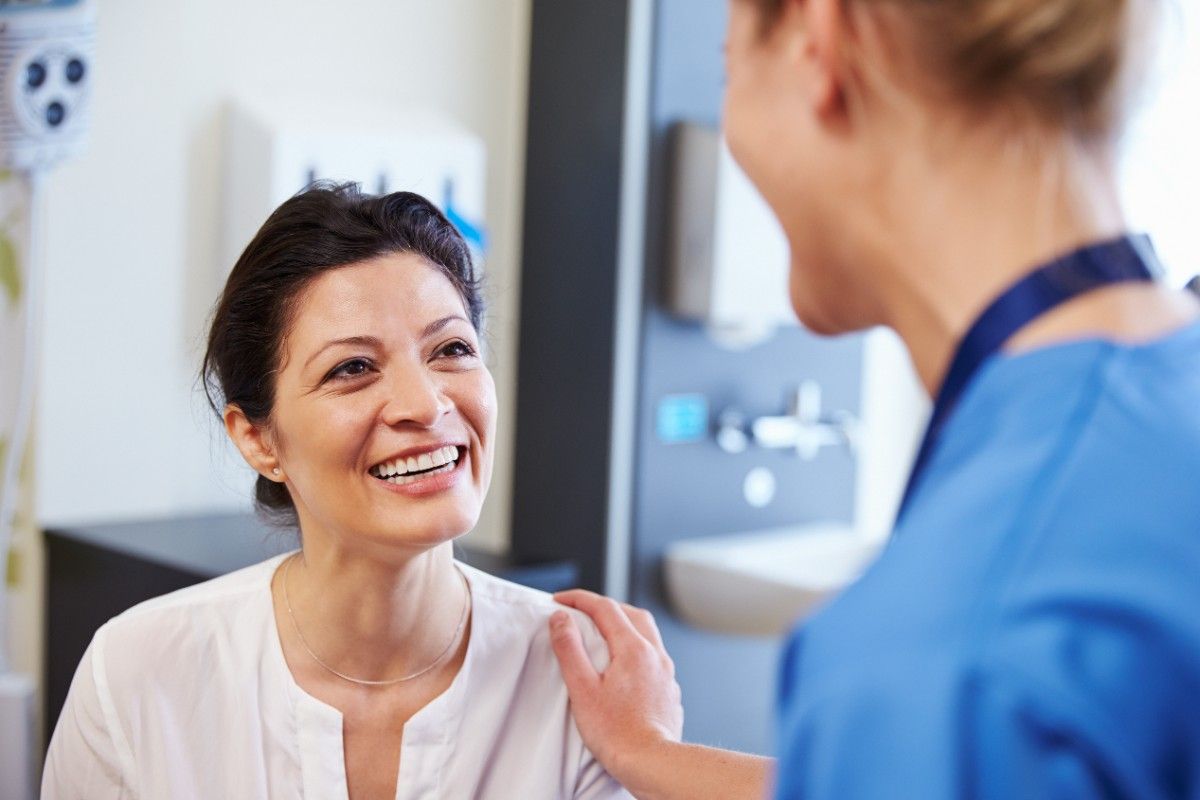 Smiling patient speaking with dentist during consultation