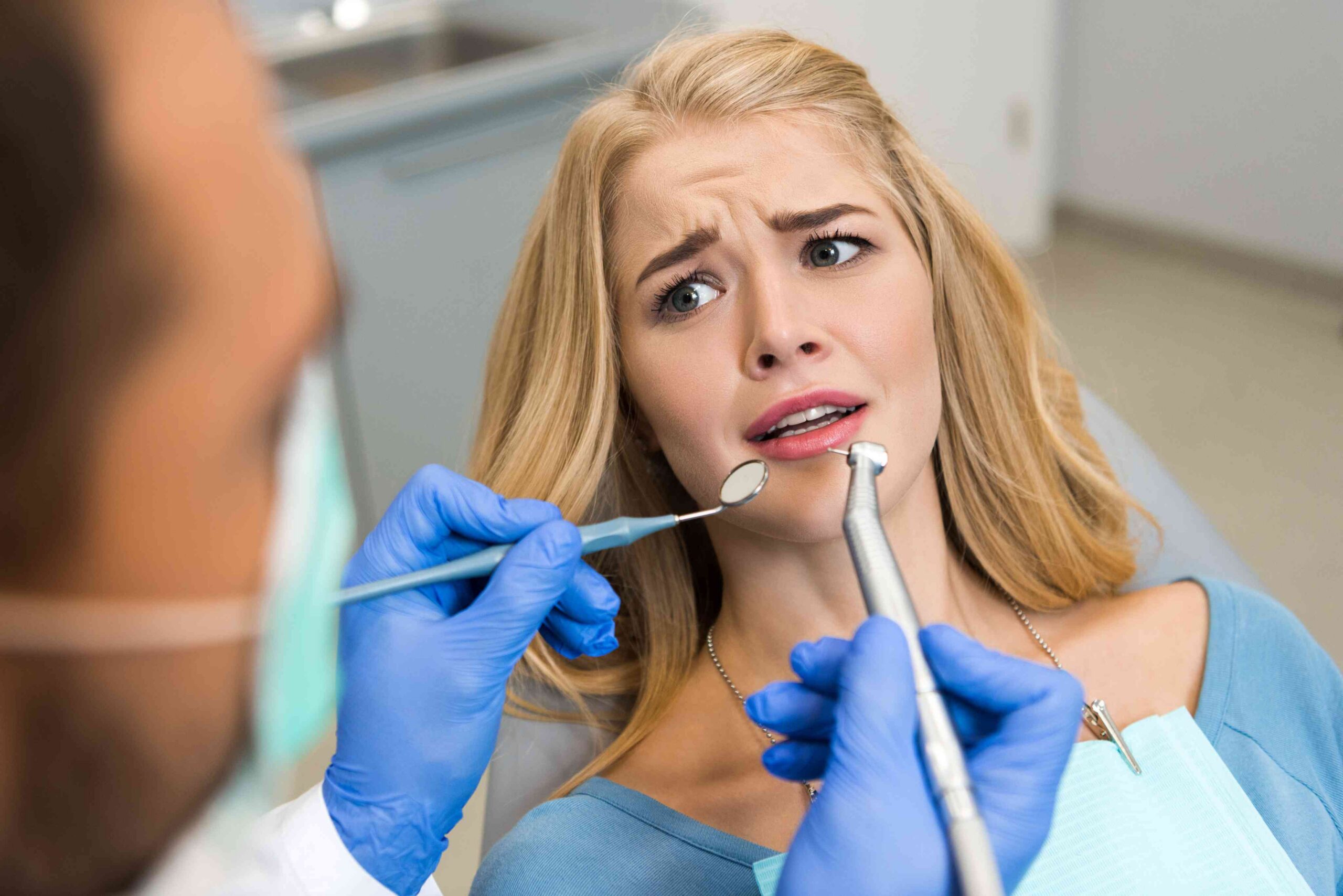 Anxious patient receiving a dental examination.